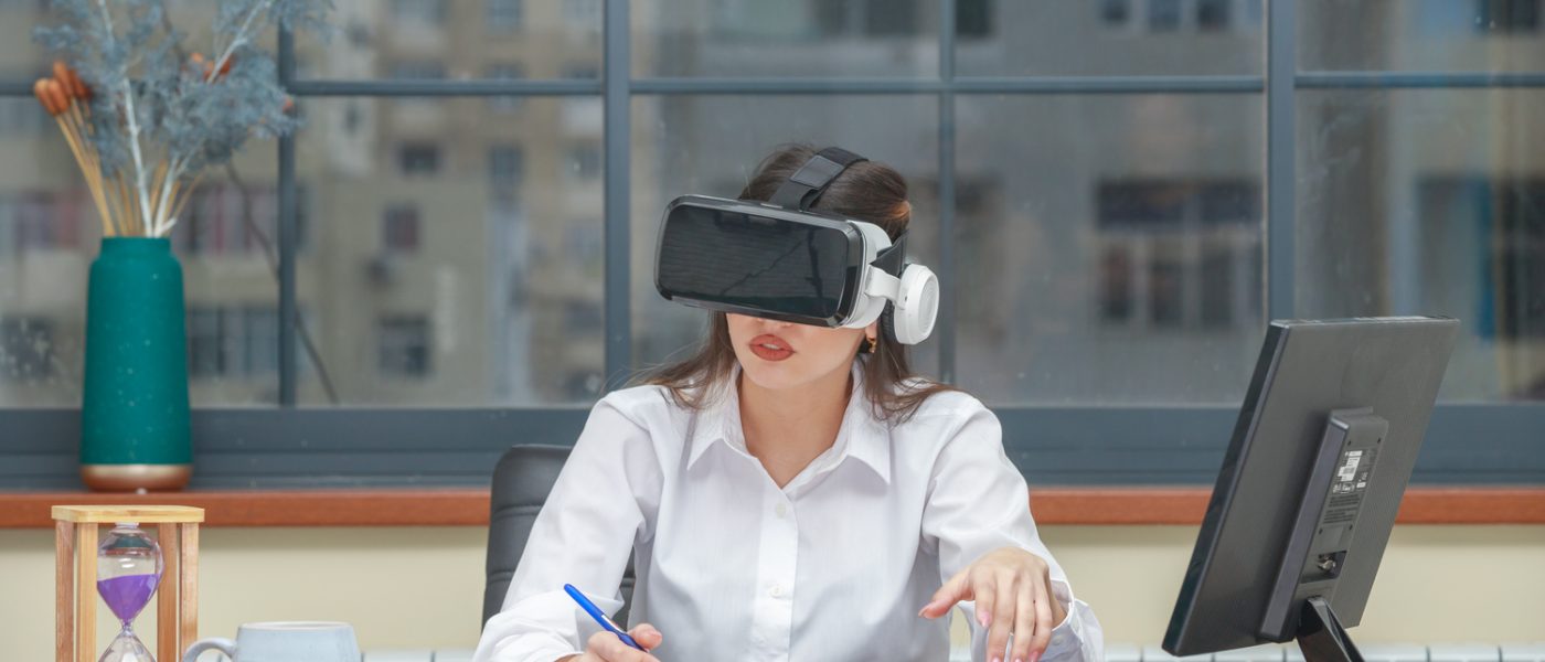 Amazed young woman wearing VR and writing. High quality photo