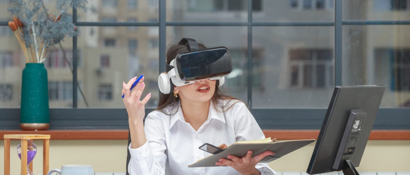 Young girl wearing VR glasses and taking notes. High quality photo